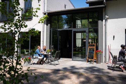 two people sitting at a table outside of a building at Tenis Park Advantage in Bielsko-Biala