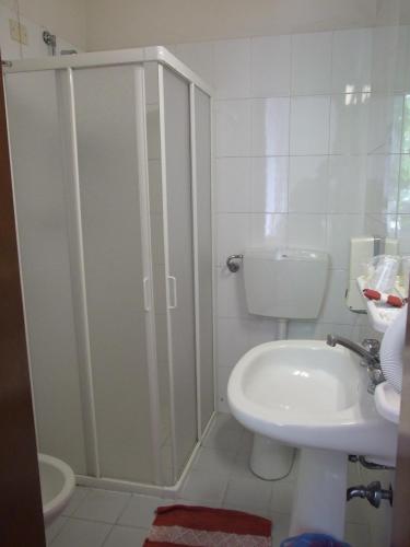 a bathroom with a shower and a toilet and a sink at Hotel Derna in Viareggio