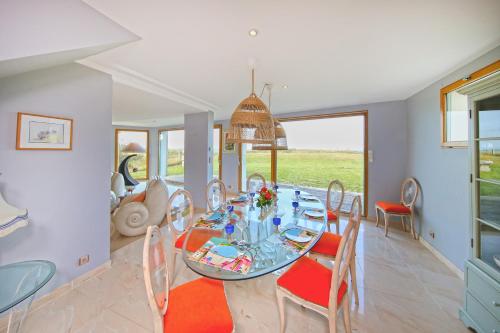 une salle à manger avec une table et des chaises dans l'établissement Les Mouettes - Maison vue mer, à Saint-Germain-sur-Ay