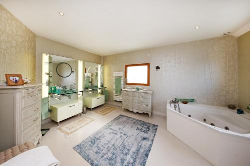 La grande salle de bains est pourvue d'une baignoire, d'un lavabo et d'une baignoire. dans l'établissement Les Mouettes - Maison vue mer, à Saint-Germain-sur-Ay