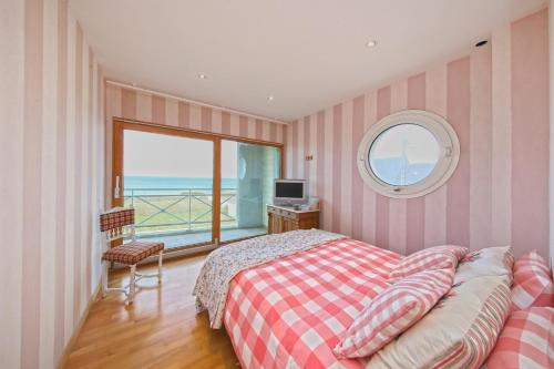 une chambre avec un lit et une fenêtre avec vue dans l'établissement Les Mouettes - Maison vue mer, à Saint-Germain-sur-Ay