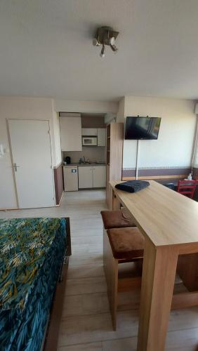 Pokój ze stołem i łóżkiem oraz kuchnią w obiekcie VACANCES OCEANES w La Rochelle