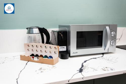 a counter top with a microwave and a box of matches at Design apartments in Netanya in Netanya