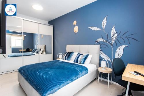 a blue bedroom with a bed with a blue wall at Design apartments in Netanya in Netanya