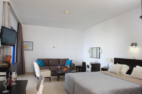 a hotel room with a bed and a couch at MarisMare Apartments in Ayia Napa
