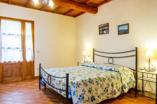 a bedroom with a bed with a floral bedspread at Geranio - Agriturismo La Fattoria in Grosseto