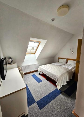 a attic bedroom with a bed and a window at Draugų namai in Druskininkai