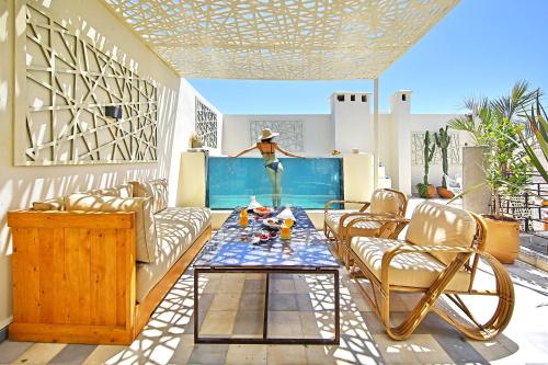 a living room with a table and chairs at Riad EspritBleu - Adult Only in Essaouira