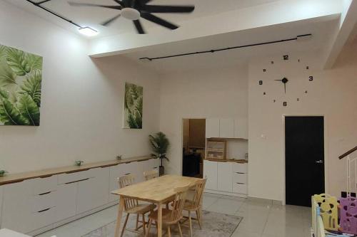 a kitchen with a table and a ceiling fan at Tamu d'Bertam Homestay in Kepala Batas