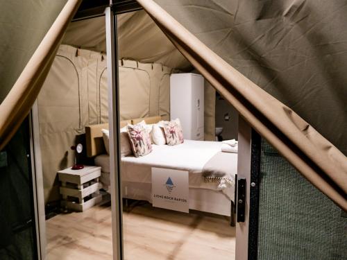 a bedroom with a bed in a tent at Lions Rock Rapids - Lodge in Hazyview
