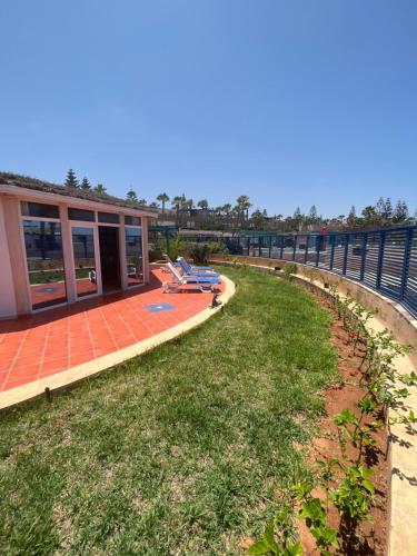 een uitzicht op een huis met een patio en een tuin bij Mimid Dunes Beach in Mirleft