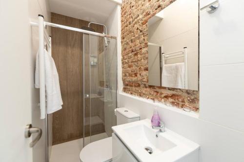 een badkamer met een wastafel en een glazen douche bij Apartamento 1hab con estilo cerca de Ventas in Madrid