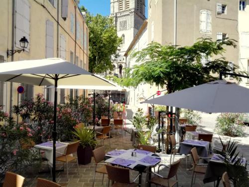 un patio al aire libre con mesas y sombrillas en Séjour à Béziers, en Béziers
