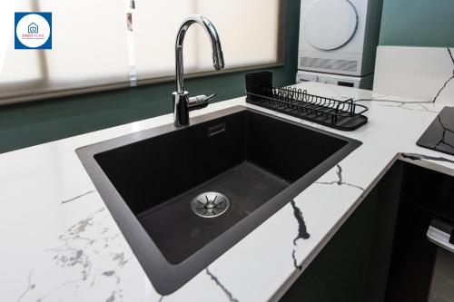 a black kitchen sink with a faucet at Design apartments in Netanya in Netanya