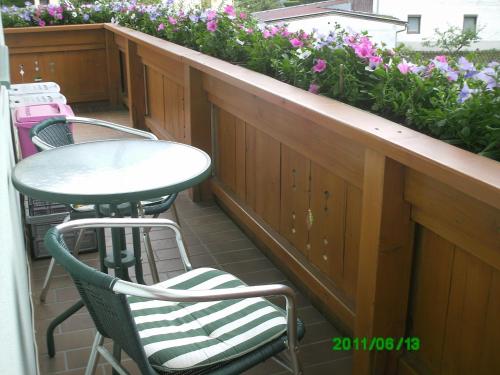 a table and chairs on a balcony with flowers at Ferienwohnungen Egger in Zell am Ziller