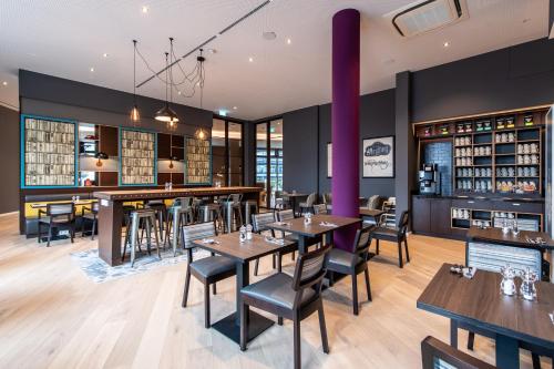 a restaurant with tables and chairs and a bar at Premier Inn Stuttgart Feuerbach in Stuttgart