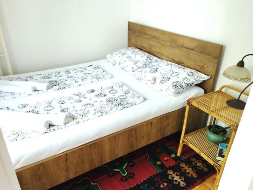 a bedroom with a wooden bed with white sheets at Apartman Amigo-Free public parking in Sarajevo