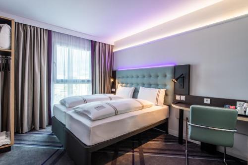 a bedroom with a large bed and a desk in it at Premier Inn Stuttgart Feuerbach in Stuttgart