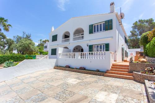 uma grande casa branca com um pátio em Villa Xaloc em Cala Galdana