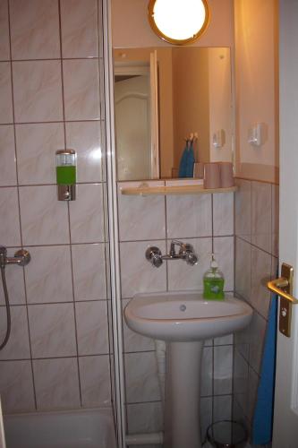 a bathroom with a sink and a shower at Pensjonat Willa Edyta in Mrągowo