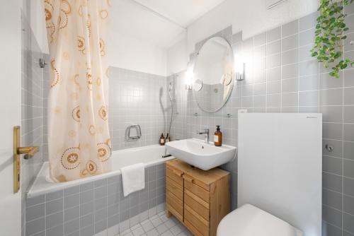 ein Badezimmer mit einem Waschbecken, einer Badewanne und einem WC in der Unterkunft "Boho Oase" with lake view and pool in Därligen