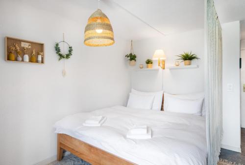 a bedroom with a white bed with white pillows at "Boho Oase" with lake view and pool in Därligen