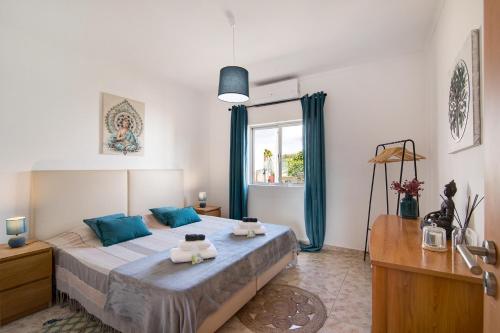 een slaapkamer met een groot bed met blauwe kussens bij Horta Teresa in Quarteira