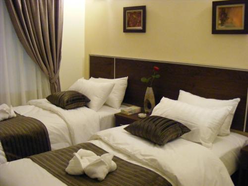 a hotel room with two beds with white sheets at Ream Hotel Amman in Amman