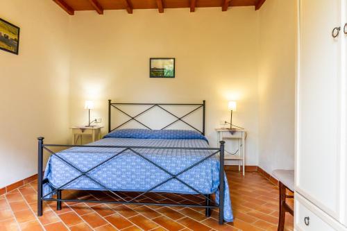 ein Schlafzimmer mit einem blauen Bett in einem Zimmer in der Unterkunft Limone - Agriturismo La Fattoria in Grosseto