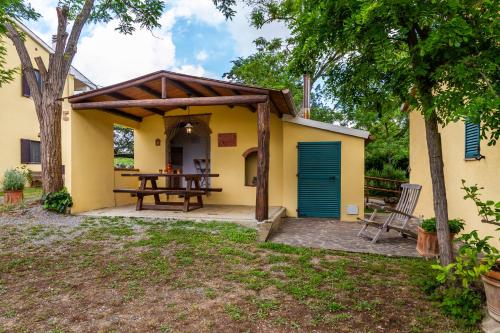a patio with a table and a house at Limone - Agriturismo La Fattoria in Grosseto