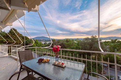a table with a vase of flowers on a balcony at Corfu Bleview Suite in Kanoni
