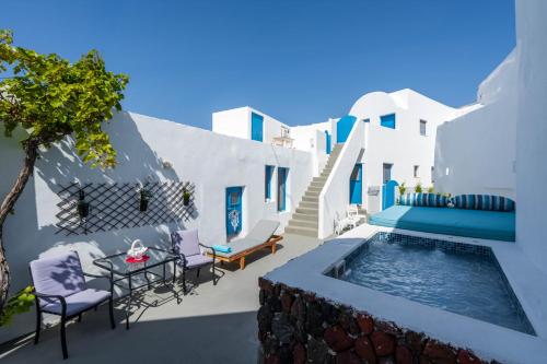 a patio with a pool and chairs and a table at Santorita Suites in Akrotiri