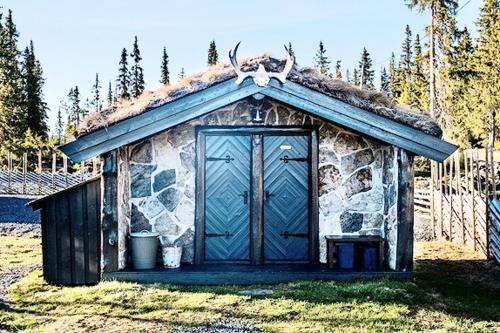 a small out house with a blue door at A cozy shelter in beautifull nature in Tisleidalen