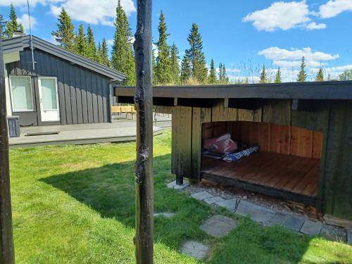 a wooden house with a deck in a yard at A cozy shelter in beautifull nature in Tisleidalen