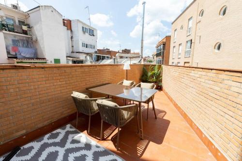 a balcony with a table and chairs on a brick wall at Amplio y cómodo apartamento cerca Plaza Castilla in Madrid