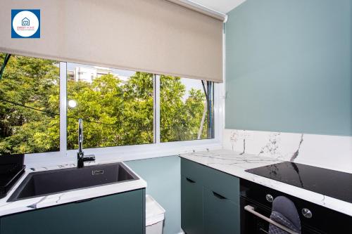 eine Küche mit einem Waschbecken und einem großen Fenster in der Unterkunft Design apartments in Netanya in Netanya