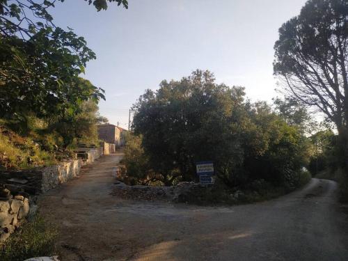 a dirt road with trees and a sign on it at Πύργος Καπουλέα in Limbókhova