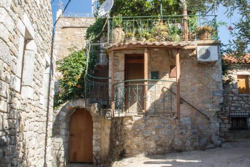 an old stone building with a door and a balcony at Πύργος Καπουλέα in Limbókhova