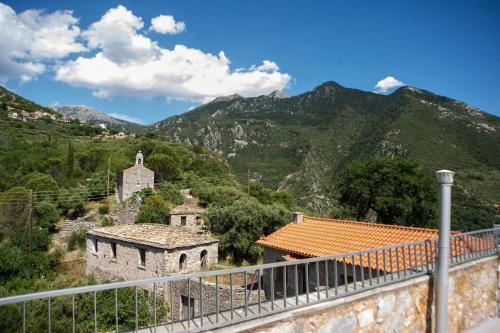 an old building on a hill with mountains in the background at Πύργος Καπουλέα in Limbókhova