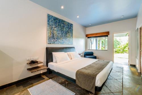 1 dormitorio con 1 cama grande y 1 silla azul en Argo by Trance en Dabolim
