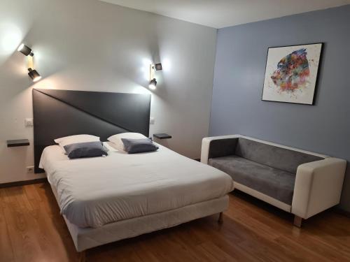 1 dormitorio con 1 cama y 1 sofá en Hôtel Restaurant Le Victor Hugo, en Sainte-Foy-la-Grande