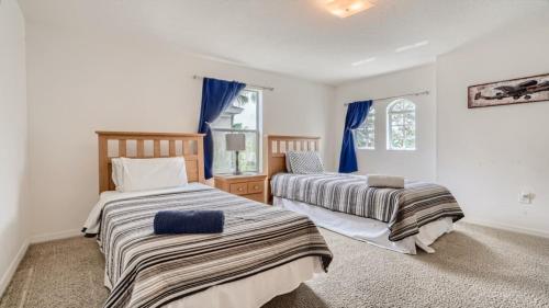 2 camas en una habitación con cortinas azules en 509pd- Perfect Pool Time Villa, en Haines City