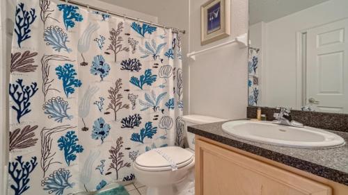 y baño con aseo y cortina de ducha. en 509pd- Perfect Pool Time Villa, en Haines City