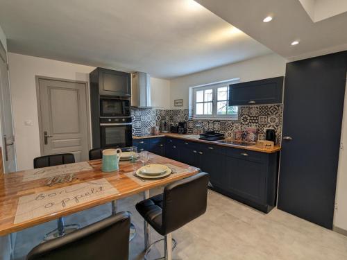 eine Küche mit einem großen Holztisch mit Stühlen in der Unterkunft Gîte lumineux avec jardin privatif, proche Château de La Rochefoucauld, équipements bébé et vélos inclus - FR-1-653-232 in La Rochefoucauld