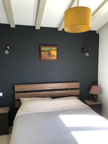 une chambre avec un grand lit avec un mur noir dans l'établissement Villa Castillon, à Paradou