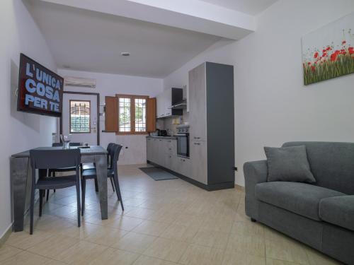 eine Küche und ein Wohnzimmer mit einem Sofa und einem Tisch in der Unterkunft PALMA RESIDENCE - Dependance LE MAGNOLIE in Marco Simone
