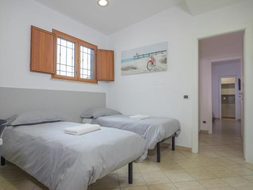 Duas camas num quarto com paredes brancas em PALMA RESIDENCE - Dependance LE MAGNOLIE em Marco Simone