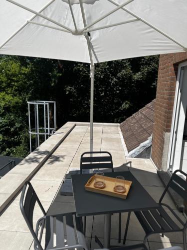 a table and chairs under an umbrella on a patio at Appartement Parkzicht in Geel
