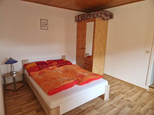 a bedroom with a large bed with a mirror at Gemütliche kleine Wohnung in Korbach