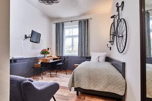 Un dormitorio con una cama y un escritorio con una bicicleta en la pared en Hotel & Restaurant Grenzhof, en Heidelberg